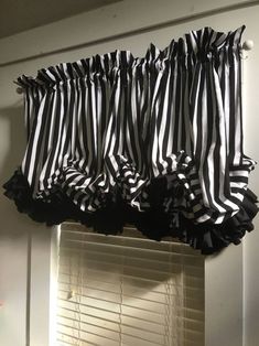 the black and white striped curtains are hanging above the window