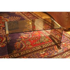 a glass coffee table sitting on top of a rug