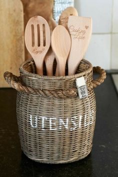 wooden utensils in a woven basket on a kitchen counter with the word utensil written on it