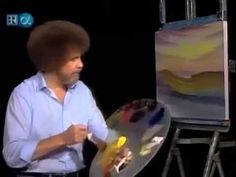 a man holding a paintbrush in front of an easel