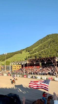 a horse show with people watching and waving