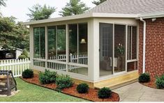 a screened in porch with landscaping around it