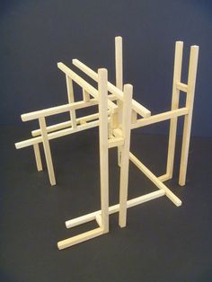 a wooden structure made out of sticks on a black surface