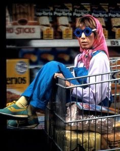 a woman sitting on top of a shopping cart