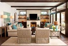 a living room filled with furniture and a flat screen tv mounted on the wall above a fireplace