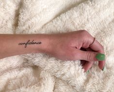 a woman's arm with a tattoo that says confliances on it