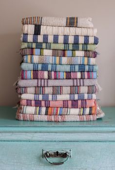 a stack of towels sitting on top of a blue dresser