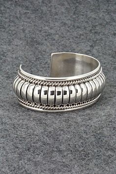 This stunning sterling silver bracelet was made by Navajo silversmith Thomas Charley. The inside is signed TC and stamped sterling.Size: 5 1/4" (will fit up to a 6 1/2" wrist)Gap: 1 1/4"Width: 1"Free shipping on all orders! We ship with USPS and always include tracking. All orders ship within a day of payment.Returns are accepted up to 30 days after you receive your order. Just send us a message. Our shop offers cash back or store credit. The item must be returned in new condition. Southwestern Silver Bangle Jewelry, Southwestern Style Silver Round Cuff Bracelet, Sterling Silver Southwestern Round Cuff Bracelet, Southwestern Sterling Silver Round Cuff Bracelet, Silver Southwestern Style Bracelet With Oyster Clasp, Southwestern Sterling Silver Cuff Bracelet In Silver, Southwestern Sterling Silver Polished Bangle Bracelet, Southwestern Sterling Silver Bangle With Polished Finish, Southwestern Polished Sterling Silver Bangle