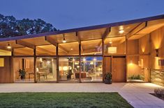 a modern house with glass walls and wooden roof