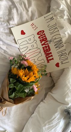 a bouquet of flowers sitting on top of a bed next to a sign that says happy birthday