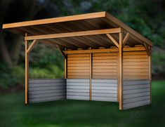 a small wooden shelter sitting on top of a lush green field