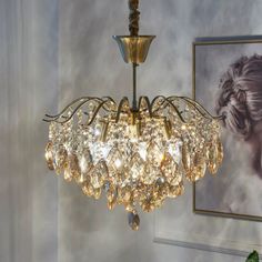 a chandelier hanging from the ceiling in a room with paintings on the wall