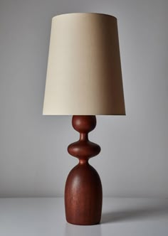 a wooden table lamp with a white shade on it