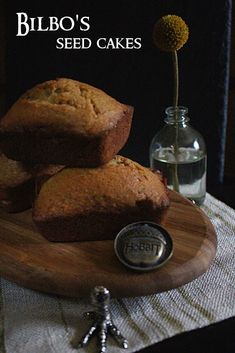 three muffins sitting on top of a wooden cutting board next to a bottle