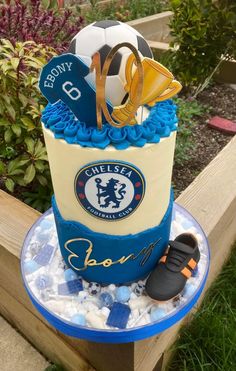 a birthday cake made to look like a soccer ball and boot with the chelsea crest on it