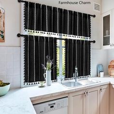 a kitchen with black and white curtains hanging from the window sill, sink and dishwasher