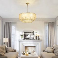 a living room filled with furniture and a fire place under a chandelier in front of a fireplace