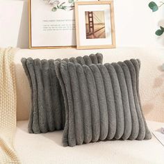 four gray pillows on a white couch