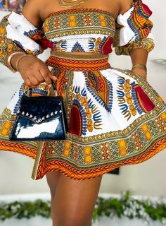 a woman in a colorful dress holding a purse