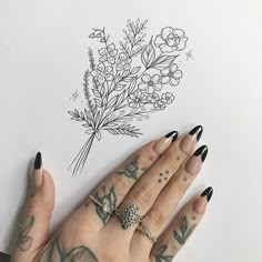 a woman's hand with tattoos and flowers on her left arm next to a drawing