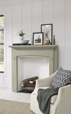 a living room with a fireplace and pictures on the mantle