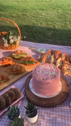 a pink cake sitting on top of a table covered in food