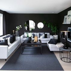 a black and white living room with couches, coffee table and mirror on the wall