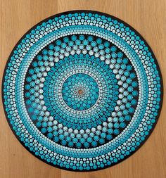 a blue and black plate sitting on top of a wooden table next to a wall