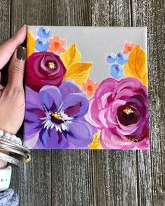 someone is painting flowers on a piece of paper