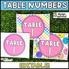 three pink and yellow table numbers are on top of each other in front of some green bushes