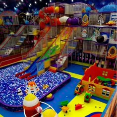 an indoor play area with toys and slides