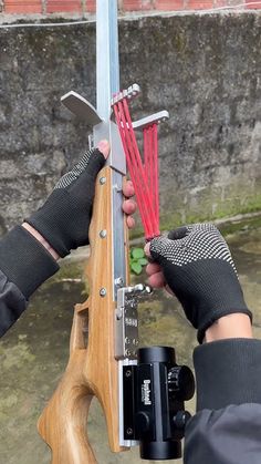 a person holding a wooden object in their hands with other hand tools attached to it