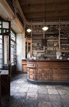 an old fashioned bar with lots of bottles on the shelves