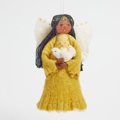 an angel ornament with a stuffed animal in it's arms and wings