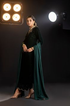 An emerald green velvet outfit with a cut-out embroidered neckline and sparkling embroidered trousers (included) is a striking and glamorous choice that combines rich color, intricate detailing, and a touch of sparkle.  Complete this ethereal look with this luxurious silk dupatta (sold separately) with sparkling sequin