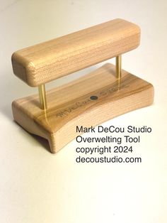 a wooden stand with a metal object on it's top that says mark decou studio overveiling tool copyright 2084