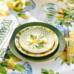 the table is set with lemons and plates