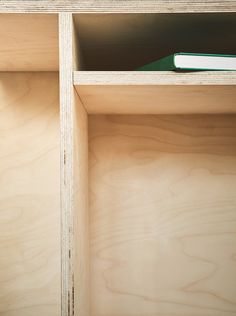 a book is sitting on top of a shelf in a room with plywood paneling