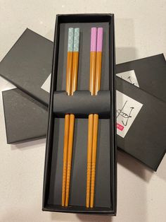 three chopsticks in a black box on a table