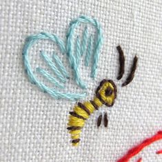 a close up of a cross stitch pattern with a bee on it's back