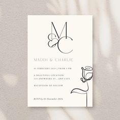 a wedding card with the letter m on it and a hand drawn design in black ink