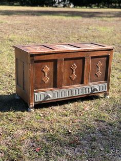 an old wooden box sitting in the grass