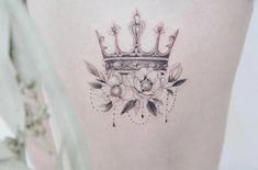 a woman's thigh with a crown and flowers tattoo on her side ribcage