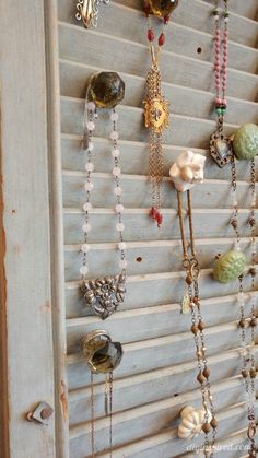 there are many different necklaces hanging on the wall in front of the door,