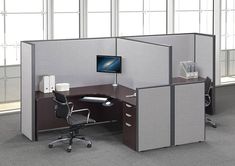 an office cubicle with two desks and a monitor