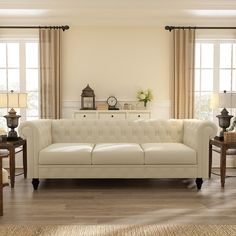 a living room with white couches and two lamps on the side tables in front of windows