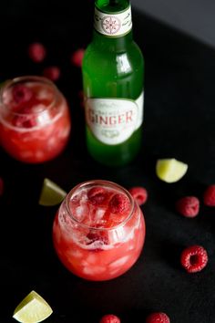 two glasses filled with raspberry lemonade next to a bottle of ginger ale