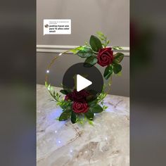 a flower arrangement with red roses and greenery