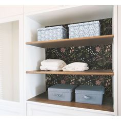 the shelves in this closet are filled with folded towels and storage bins, which also have baskets on them