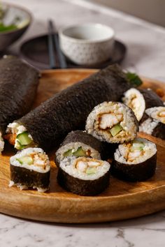 sushi rolls are arranged on a wooden platter